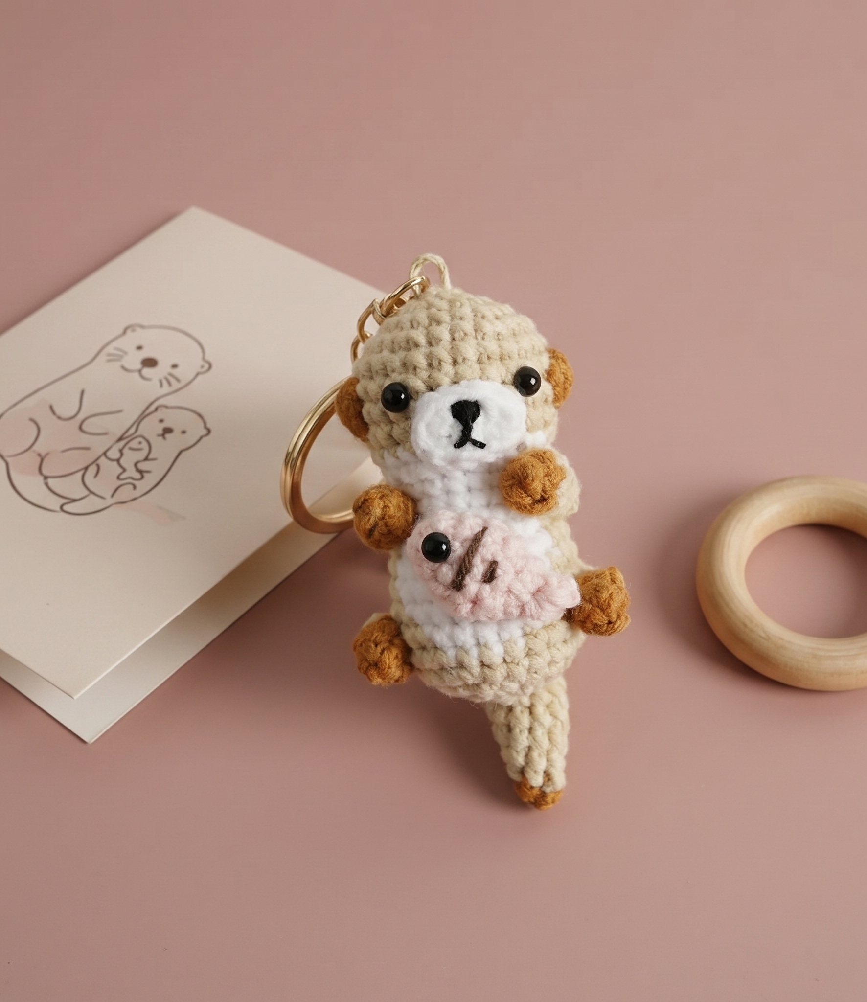 Handmade otter crochet keyring on plain background