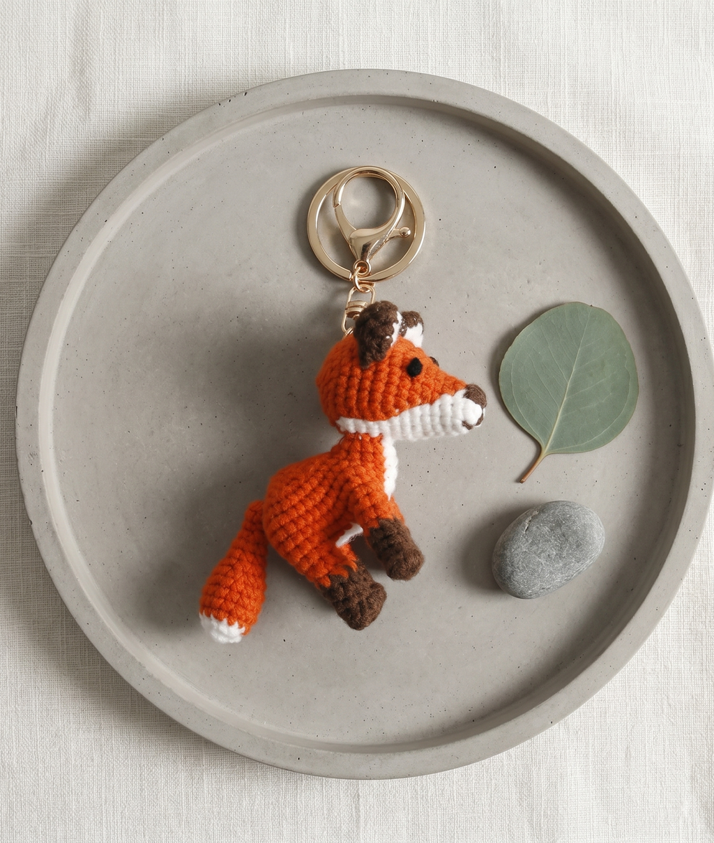 Handmade large fox crochet keyring on plain background