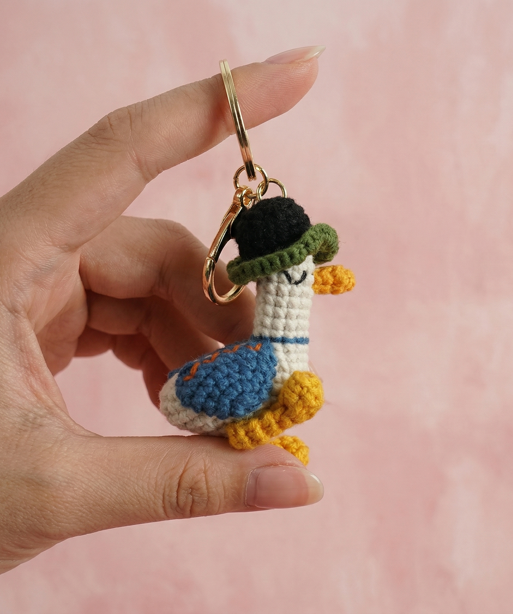 Handmade duck crochet keyring on plain background