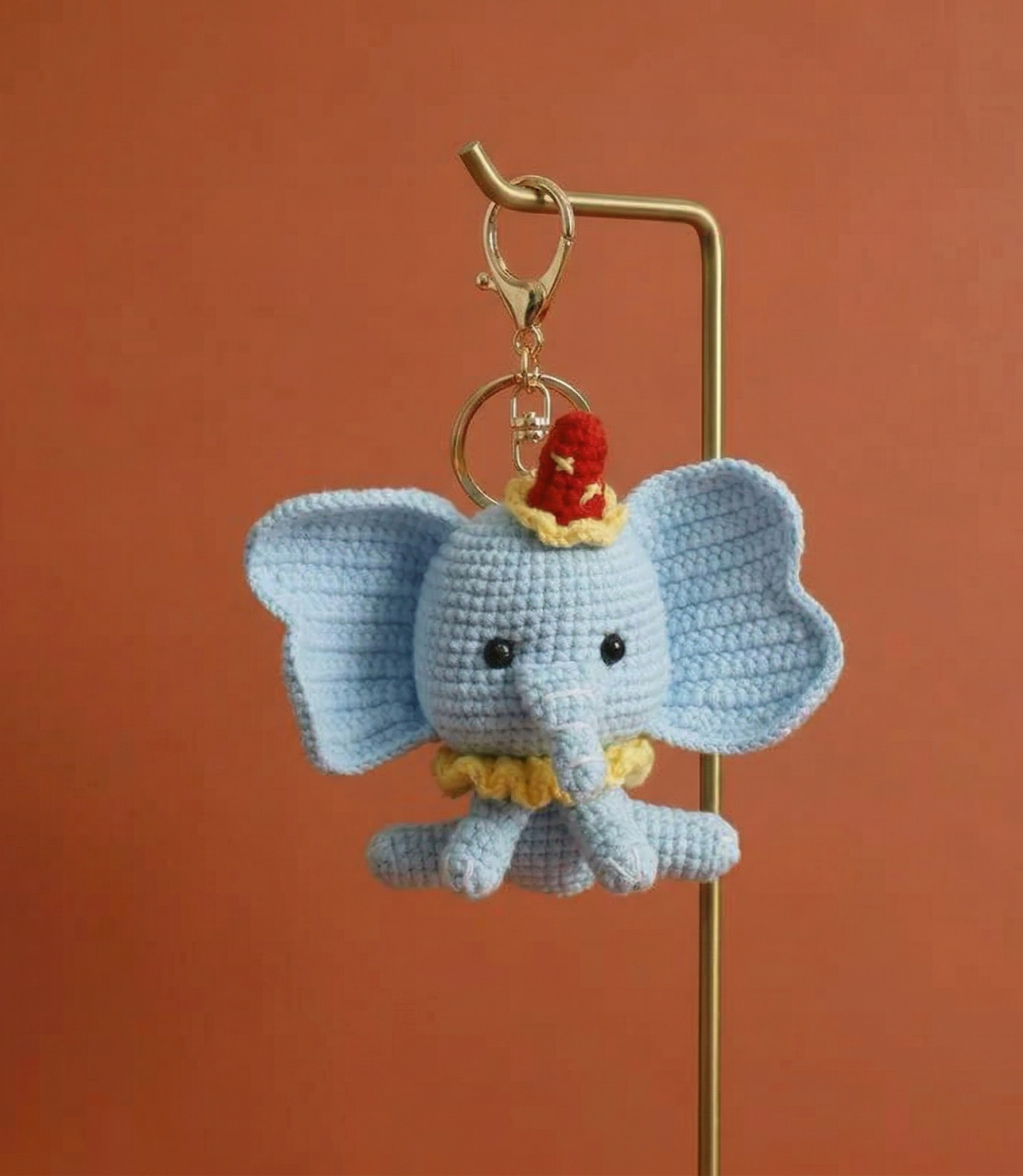 Handmade elephant crochet keyring on plain background
