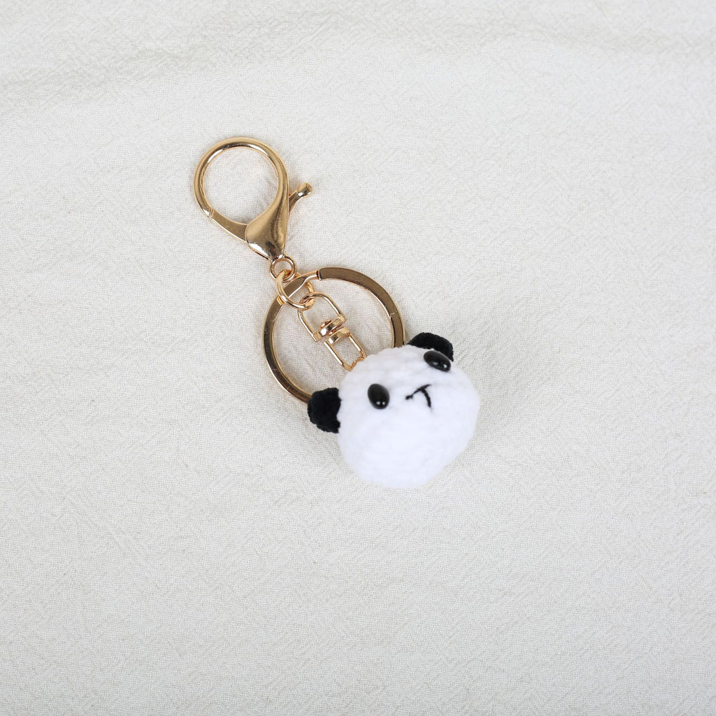 Handmade crochet panda keyring on plain background