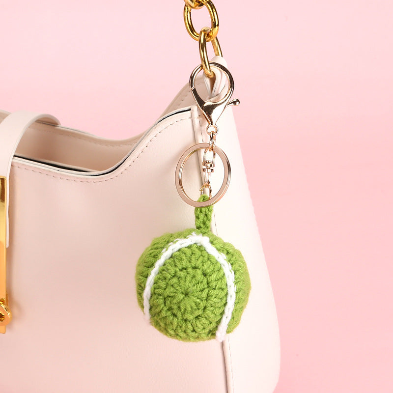 Handmade tennis ball crochet keyring on plain background