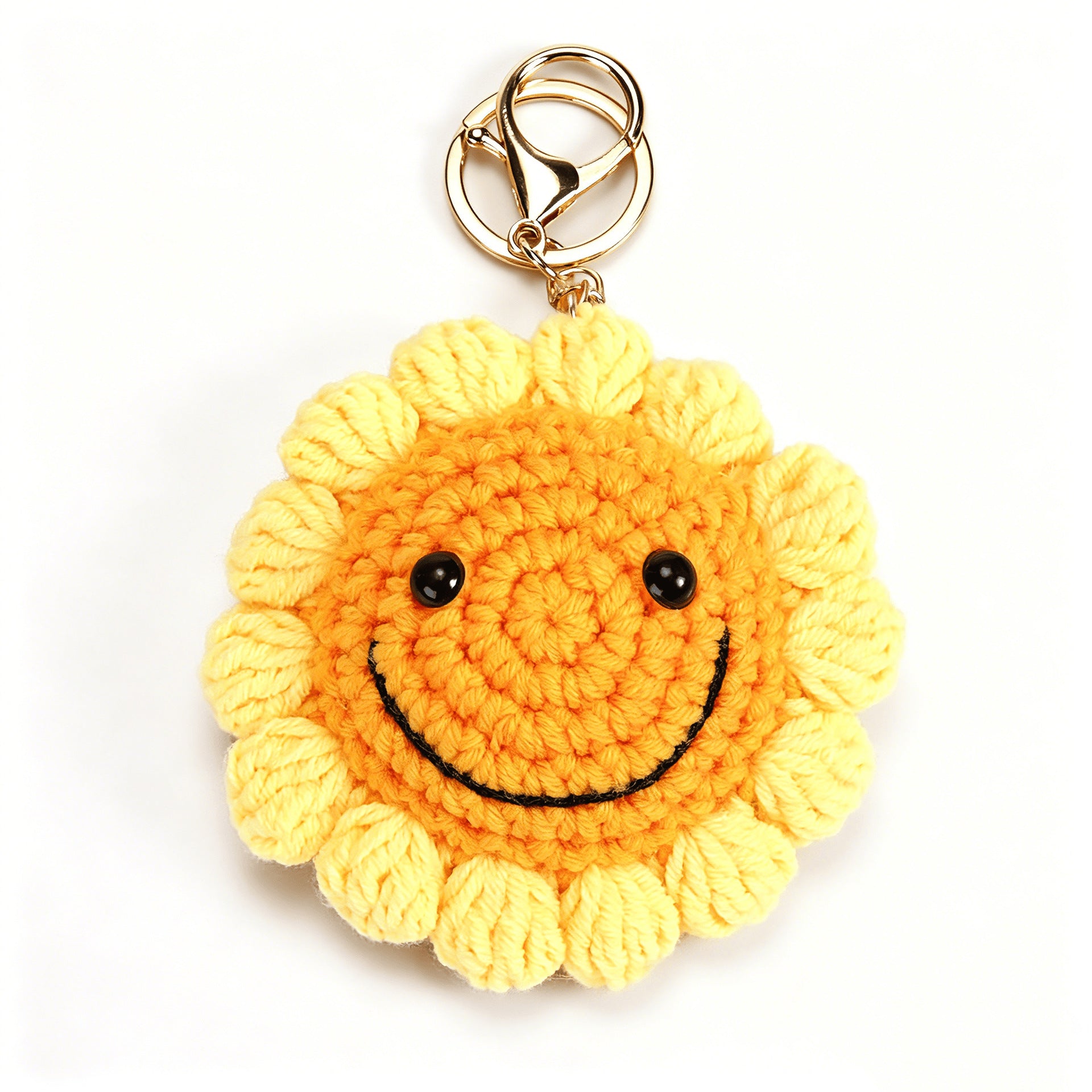 Crochet sunflower keyring showing embroidered smiling expression