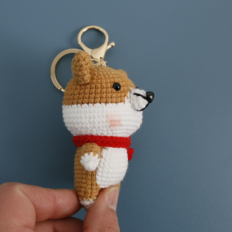 Handmade corgi with scarf crochet keyring on plain background